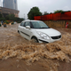 A car drives through a flooded street during heavy rains in New Delhi